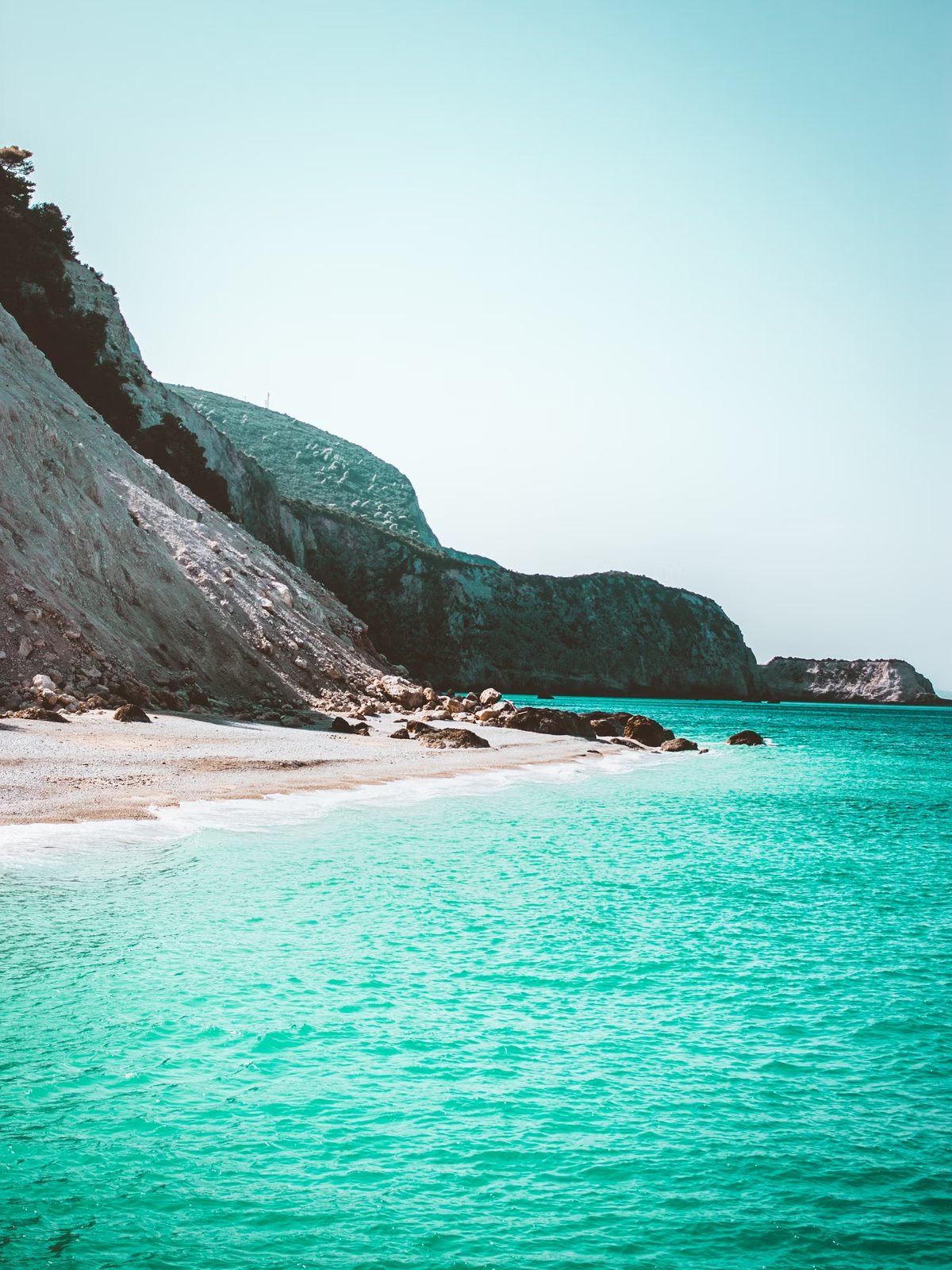 Turquoise baai met rotsen en helder water aan een kust